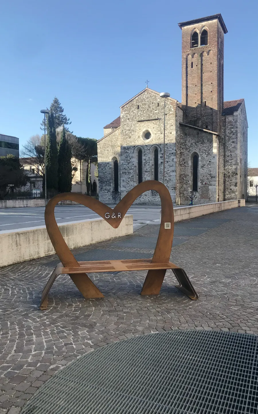 Il cuore in acciaio corten a forma di panchina in Piazza Venerio, a Udine, davanti alla chiesa di San Francesco